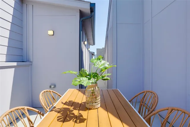 a view of a balcony with chairs and a potted plant