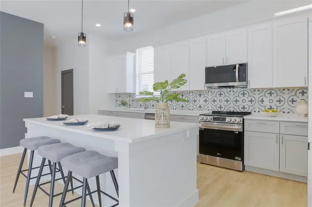 a kitchen with stainless steel appliances kitchen island granite countertop a sink and a stove