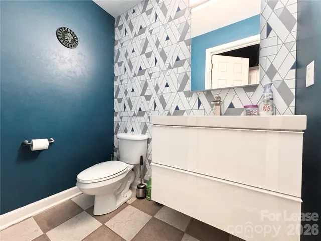 a white toilet sitting next to a white cabinet