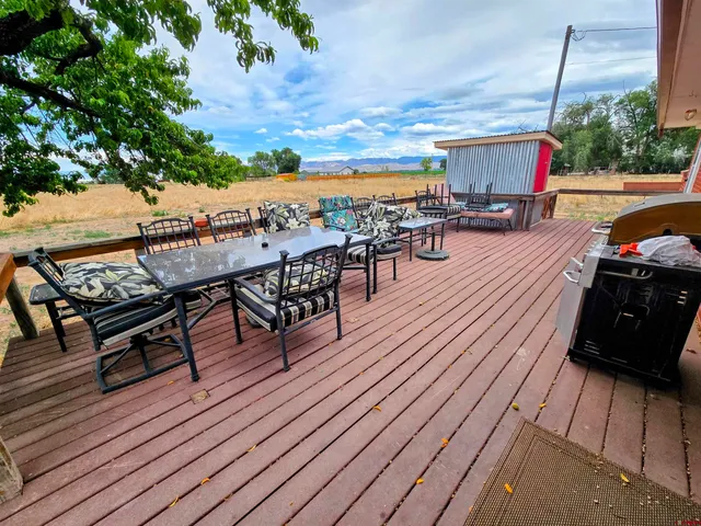 an outdoor sitting area with furniture and wooden floor