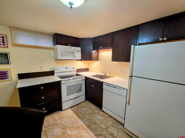 a kitchen with a refrigerator sink and cabinets