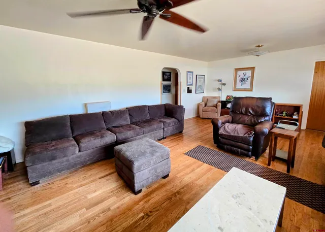 a living room with furniture and a wooden floor