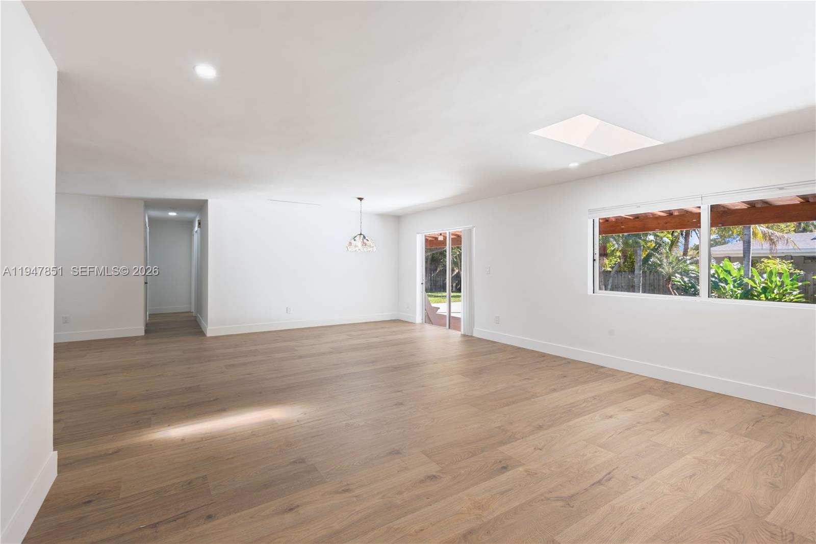 8420 Southwest 179th Street Palmetto Bay, FL 33157 - Photo 21 of 27 a view of an empty room with wooden floor and a window
