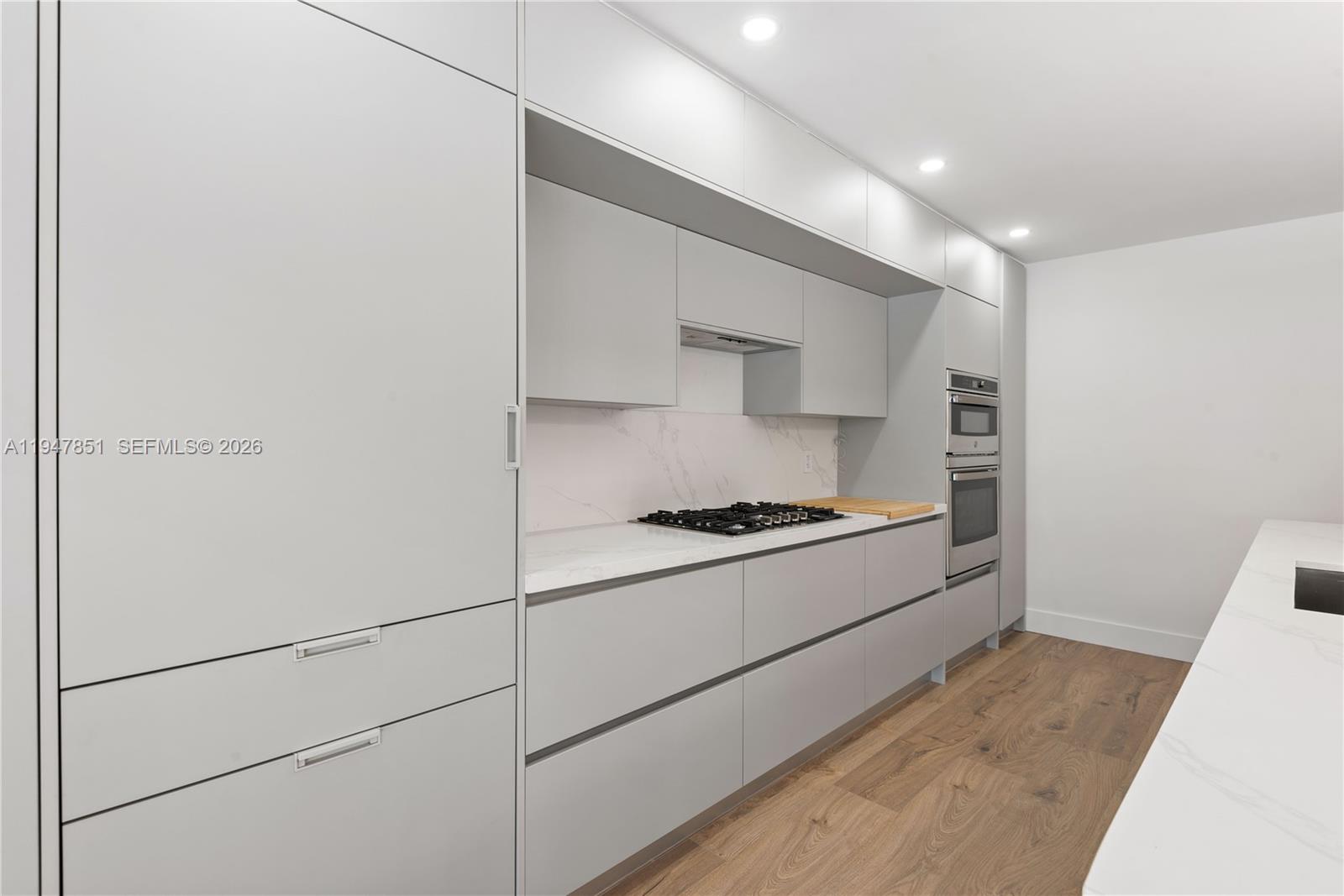 8420 Southwest 179th Street Palmetto Bay, FL 33157 - Photo 6 of 27 a kitchen with stainless steel appliances granite countertop a stove a refrigerator and a white cabinets