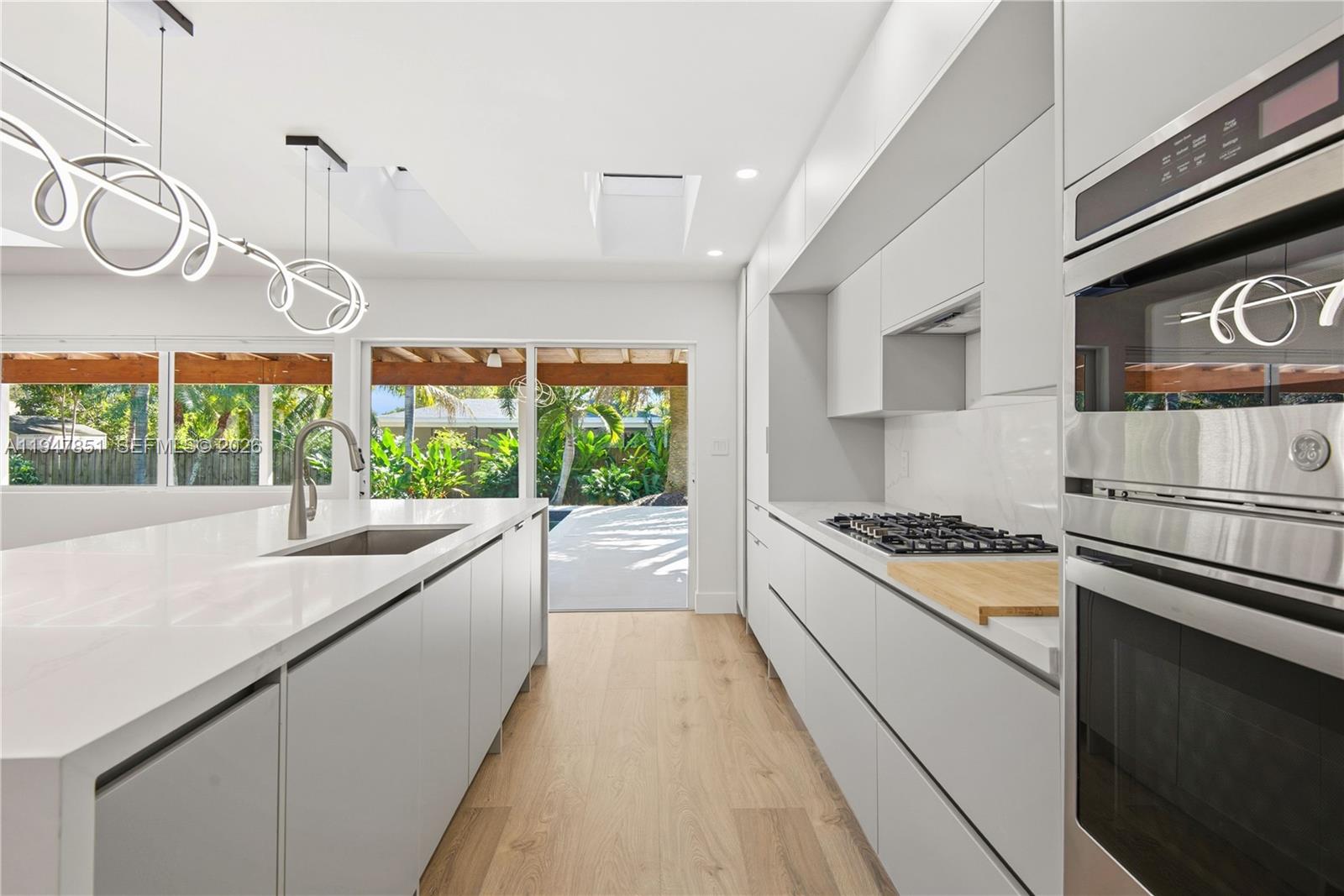 8420 Southwest 179th Street Palmetto Bay, FL 33157 - Photo 9 of 27 a kitchen with stainless steel appliances granite countertop a stove a sink and a microwave