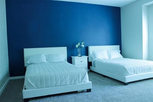 a bedroom with two beds and a night stand