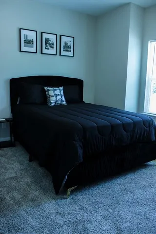 a bed sitting in a bedroom next to a window