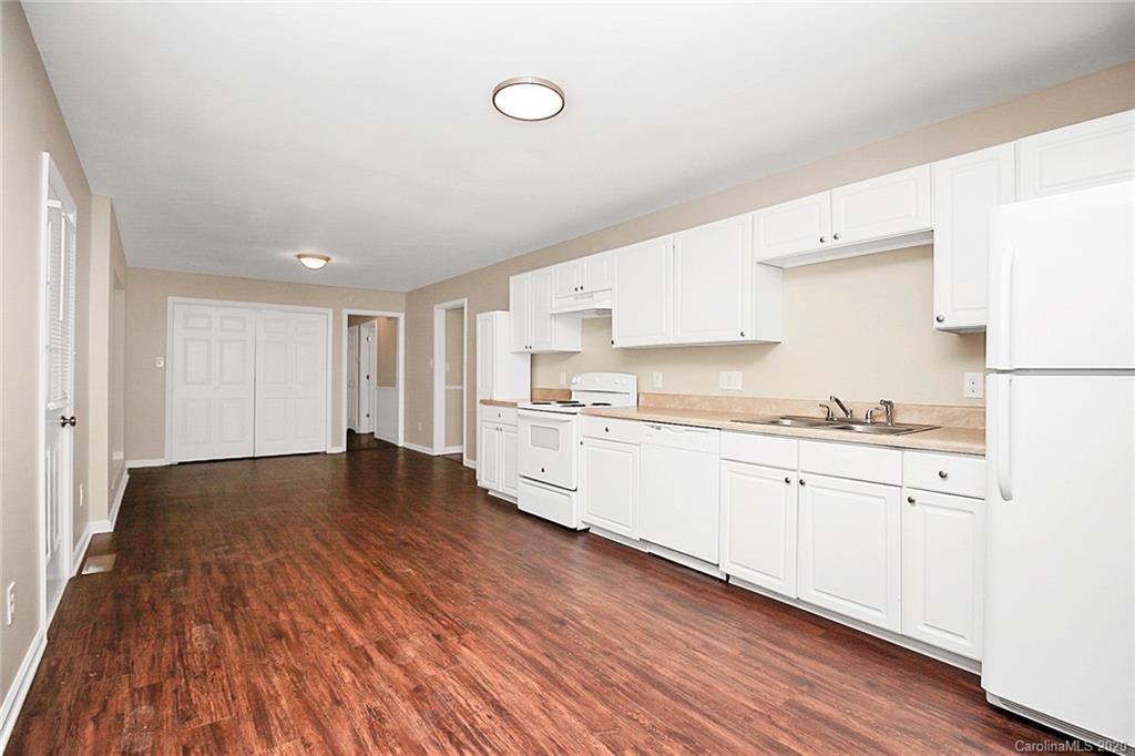 307 Harris Street Fort Mill, SC 29715 - Photo 13 of 39 a large kitchen with granite countertop a stove top oven a sink and white cabinets with wooden floor