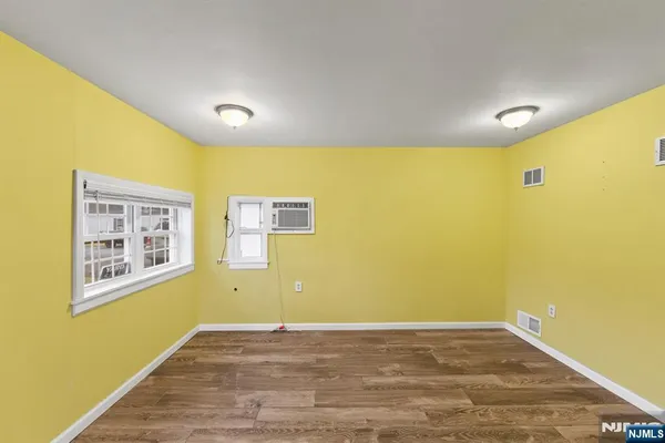 a view of a big room with wooden floor and windows