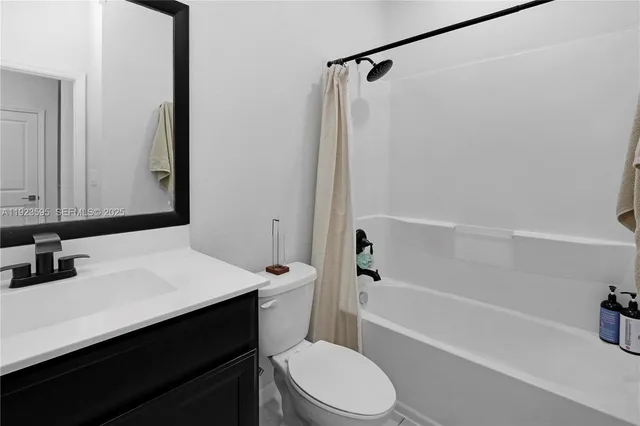 a bathroom with a sink a toilet a mirror and shower