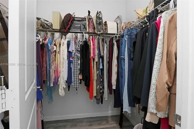 a view of walk in closet with clothes