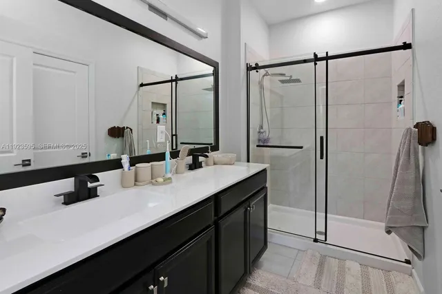 a bathroom with a double vanity sink mirror and shower