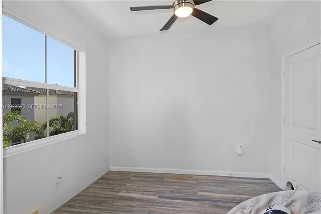a view of a room with wooden floor and fan