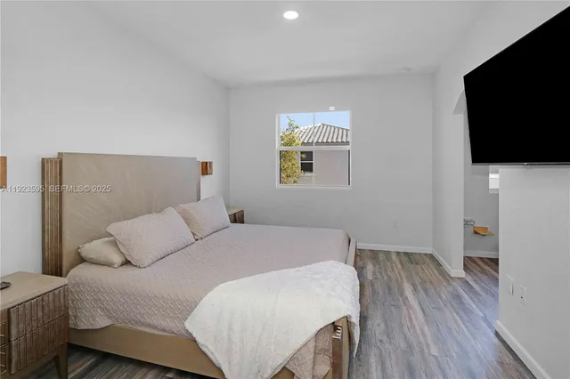 a bedroom with a bed and a flat screen tv