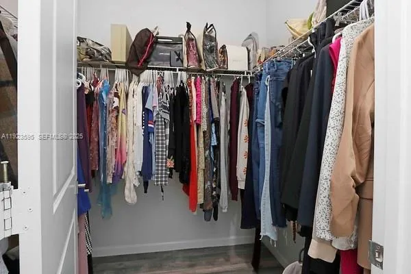 a view of walk in closet with clothes