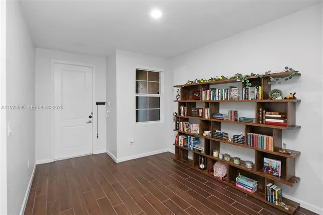 a view of a workspace with bookshelf and wooden floor