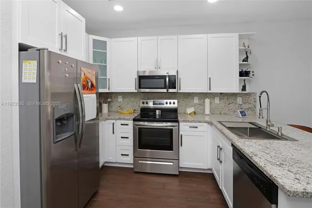 a kitchen with stainless steel appliances granite countertop a refrigerator stove and sink