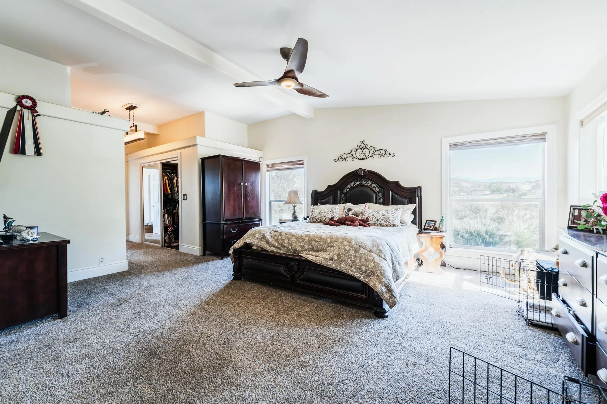 8411 Reche Canyon Road Colton, CA 92324 - Photo 14 of 30 a spacious bedroom with a bed and a chandelier