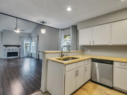 a kitchen with stainless steel appliances granite countertop a refrigerator a stove top oven a sink and dishwasher