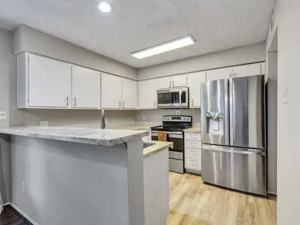 a kitchen with stainless steel appliances granite countertop a sink and a stove