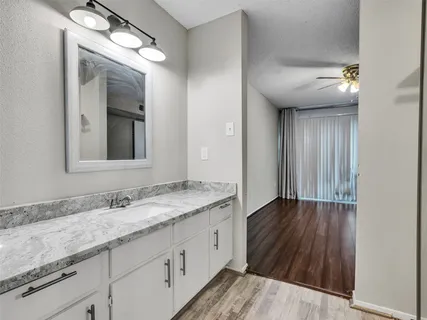 a bathroom with a granite countertop sink toilet and shower
