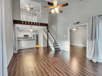 a view of a livingroom with wooden floor a ceiling fan and fireplace