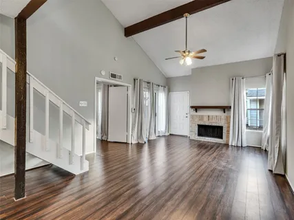 a view of a livingroom with wooden floor a fireplace and window