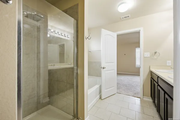 a bathroom with a granite countertop sink a large mirror and a shower