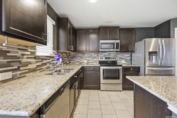 a kitchen with kitchen island granite countertop a stove sink and cabinets