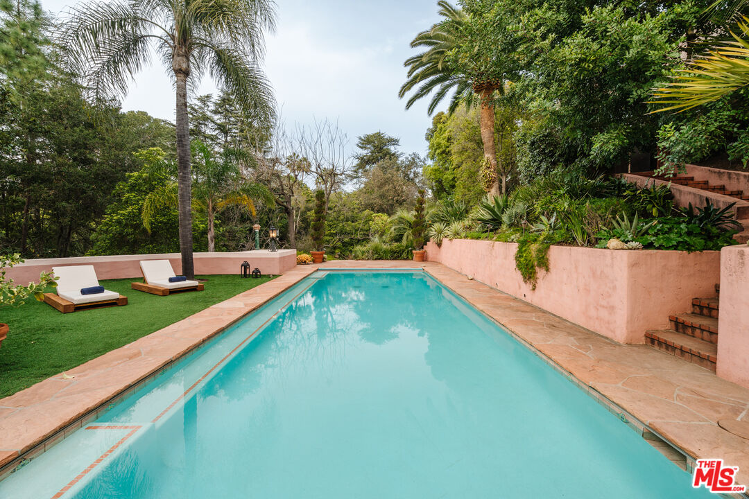 3131 Floye Drive Los Angeles, CA 90046 - Photo 41 of 53 a view of a swimming pool with a garden and trees