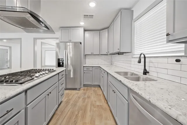 a kitchen with stainless steel appliances granite countertop a sink stove and refrigerator