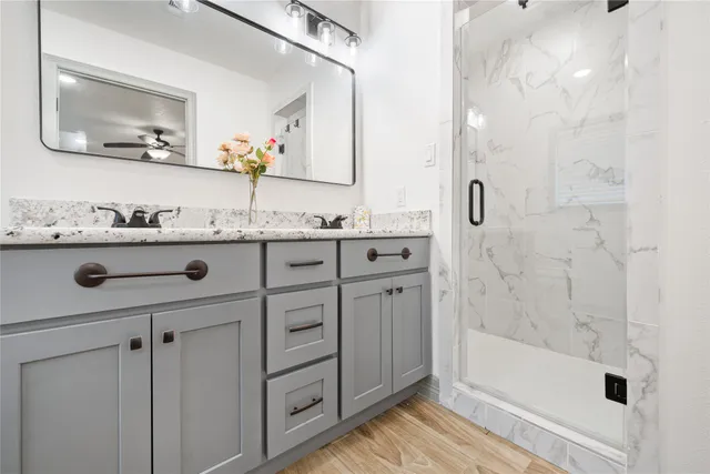 a bathroom with a granite countertop sink a mirror a vanity and bathtub