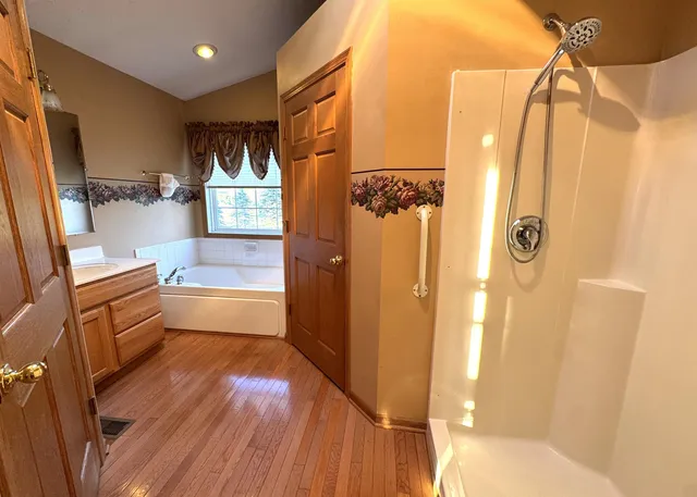 a bathroom with a tub toilet sink and mirror
