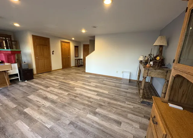 a view of a livingroom with wooden floor and furniture