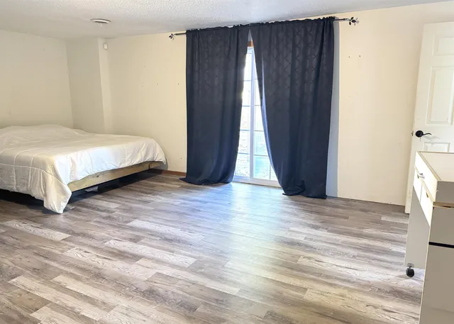 a spacious bedroom with a bed and a window