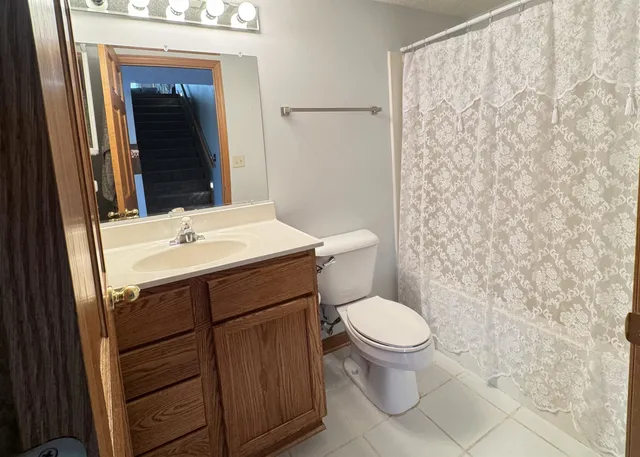 a bathroom with a sink a toilet and shower curtain