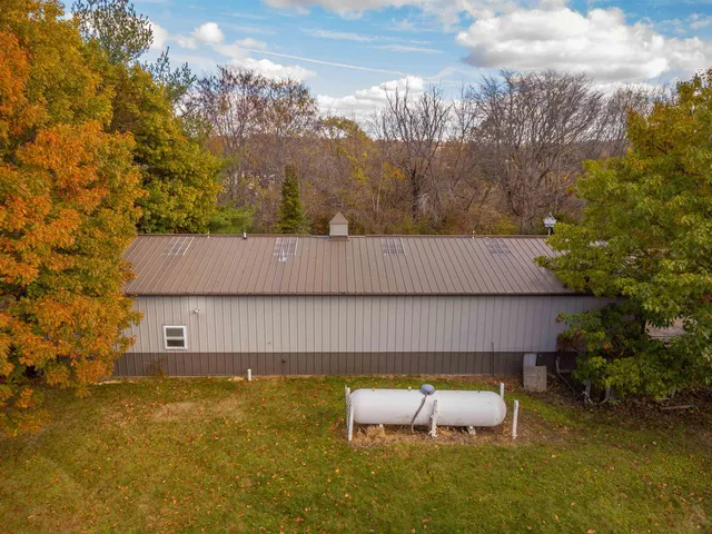 a backyard of a house with table and chairs under an umbrella