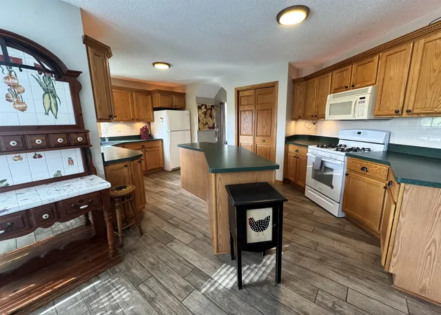 a kitchen with wooden floors and appliances