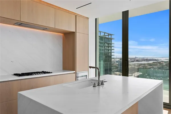 a room with kitchen island a sink a counter and a refrigerator