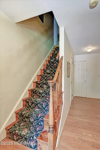 a view of a hallway with wooden floor and stairs