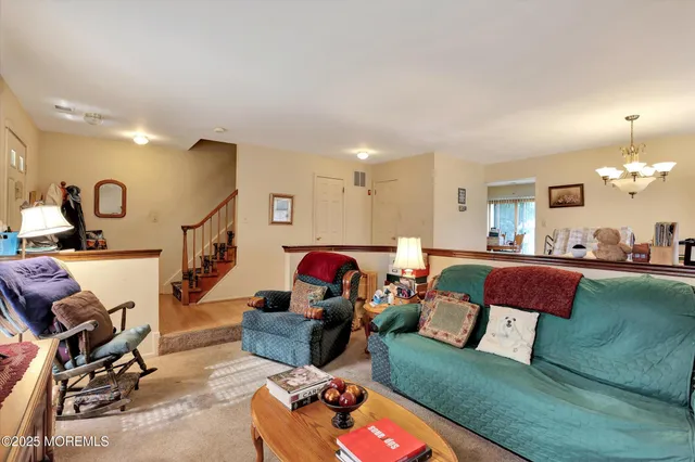 a living room with furniture a rug and gym equipment