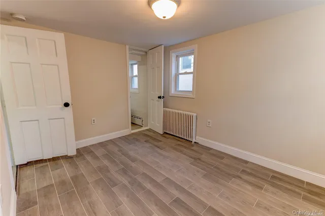 a view of a room with wooden floor and a bathroom