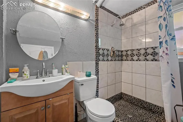 a bathroom with a sink a toilet and shower