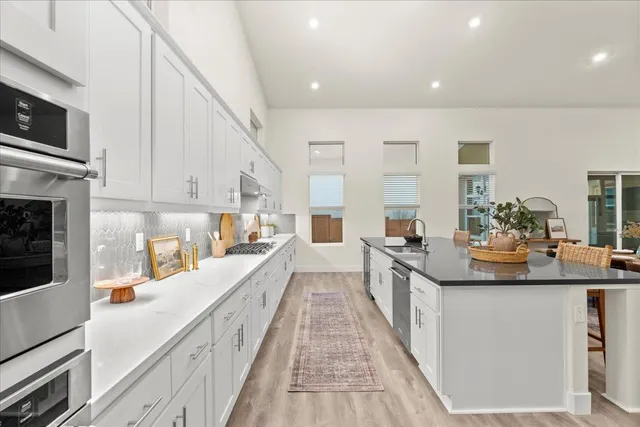 a kitchen with white cabinets and appliances