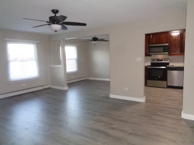 a view of a kitchen hardwood floor a ceiling fan and windows