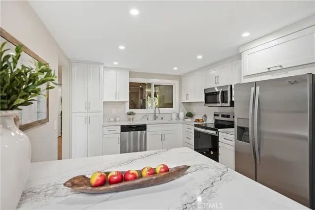 a kitchen with white cabinets sink and stainless steel appliances