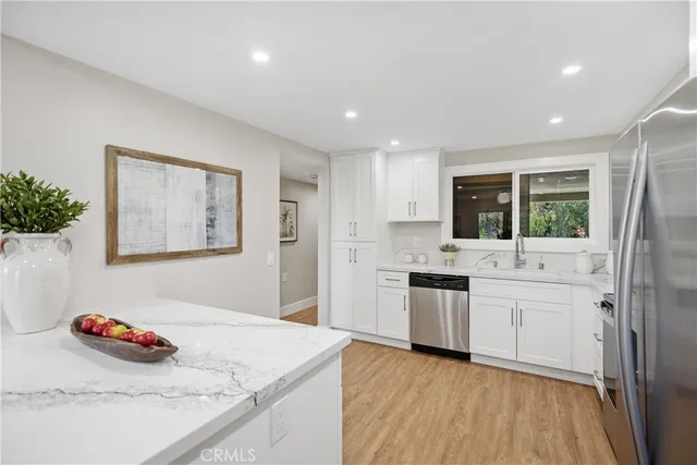 a kitchen with a refrigerator sink and cabinets