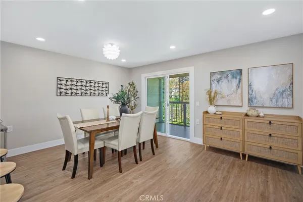 a living room with furniture two large windows and a dining table with garden view