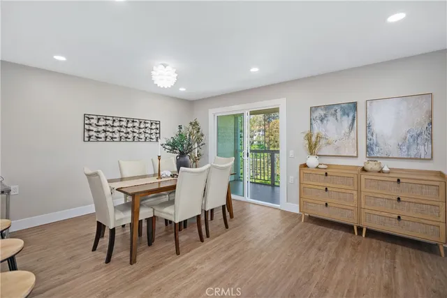 a living room with furniture two large windows and a dining table with garden view