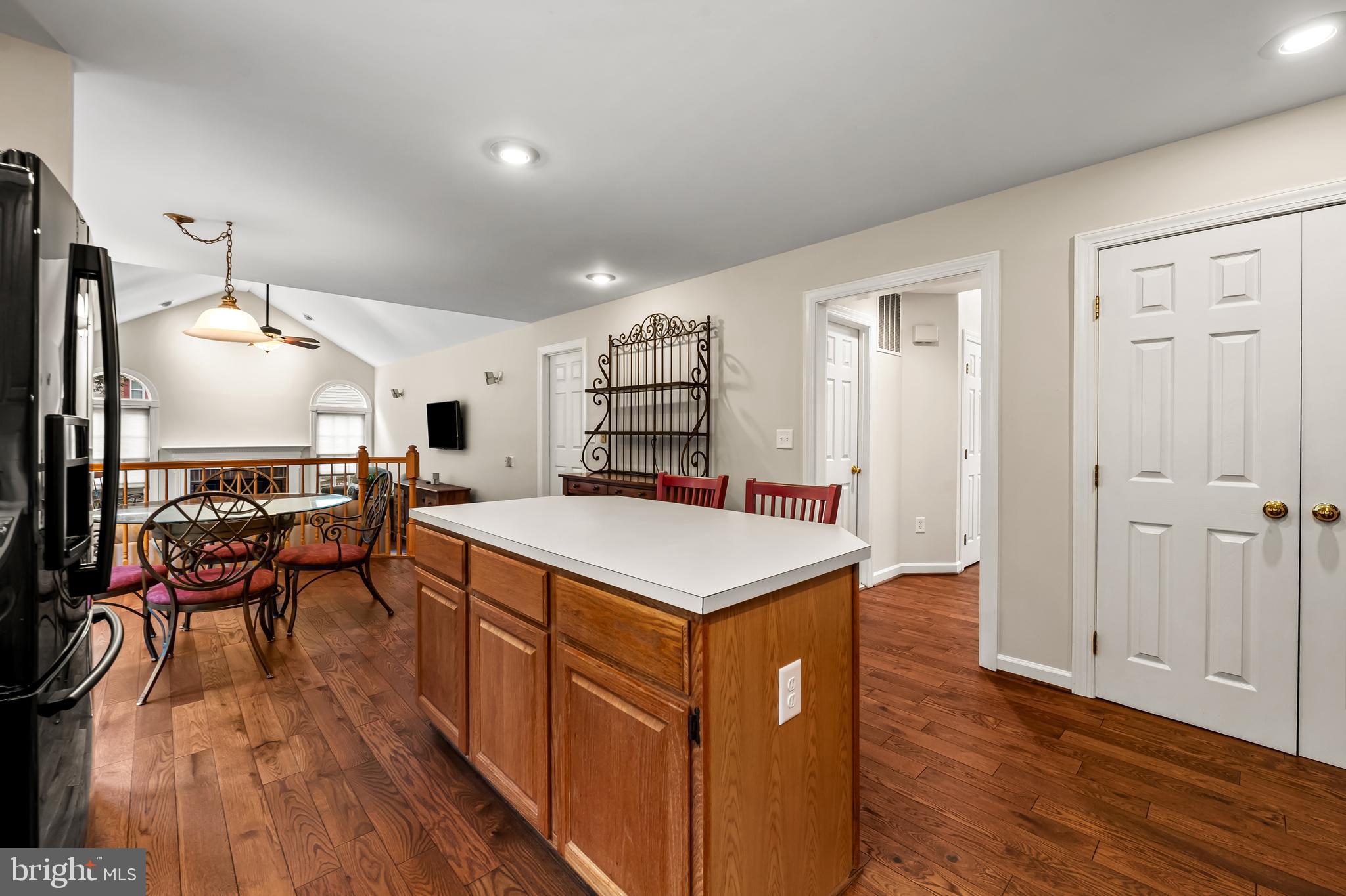 8315 Saddle Ridge Terrace Ellicott City, MD 21043 - Photo 18 of 62 a kitchen with a stove a refrigerator and a dining table with wooden floor